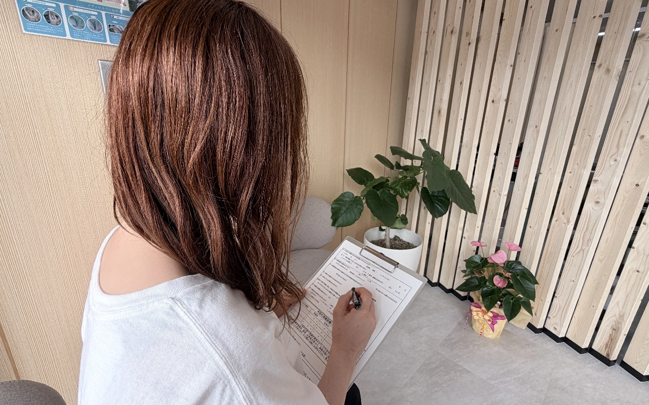 受付で問診票を記入している様子